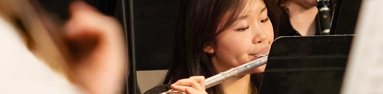 an asian american teenager plays the flute