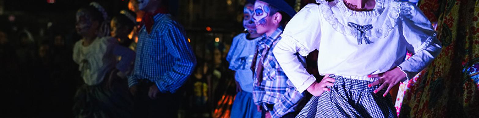 Children dancgin on stage while wearing Candy skull Make UP