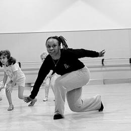 A black dancer instructs a group of young girls