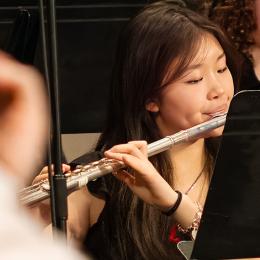 an asian american teenager plays the flute